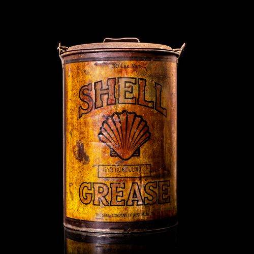 Vintage Shell oil cans with red and yellow branding from the 1900-1920 old logo Vintage Shell oil cans from 1900-19255, featuring the old logo. The photo showcases an antique tin red with yellow accents, displaying the historic Shell emblem. Shot in a studio against a solid black background