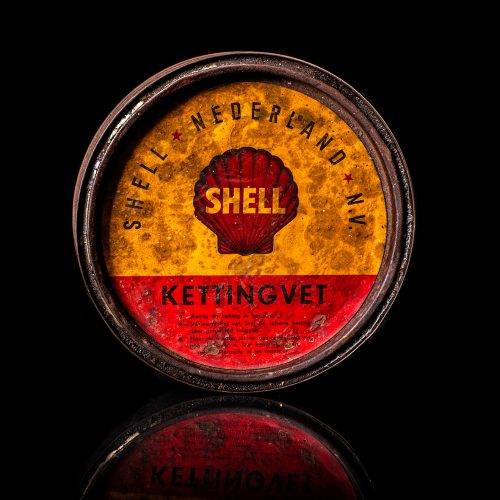 Vintage Shell oil cans with red and yellow branding from the 1900-1920 old logo Vintage Shell oil cans from 1900-19255, featuring the old logo. The photo showcases an antique tin red with yellow accents, displaying the historic Shell emblem. Shot in a studio against a solid black background