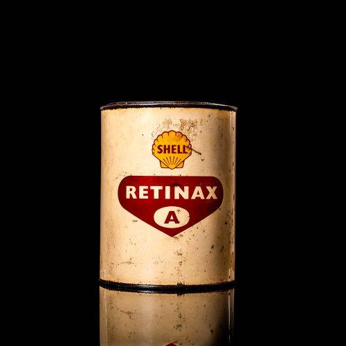 Vintage Shell oil cans with red and yellow branding from the 1900-1920 old logo Vintage Shell oil cans from 1900-19255, featuring the old logo. The photo showcases an antique tin red with yellow accents, displaying the historic Shell emblem. Shot in a studio against a solid black background