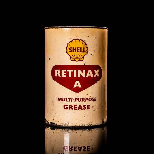 Vintage Shell oil cans with red and yellow branding from the 1900-1920 old logo Vintage Shell oil cans from 1900-19255, featuring the old logo. The photo showcases an antique tin red with yellow accents, displaying the historic Shell emblem. Shot in a studio against a solid black background
