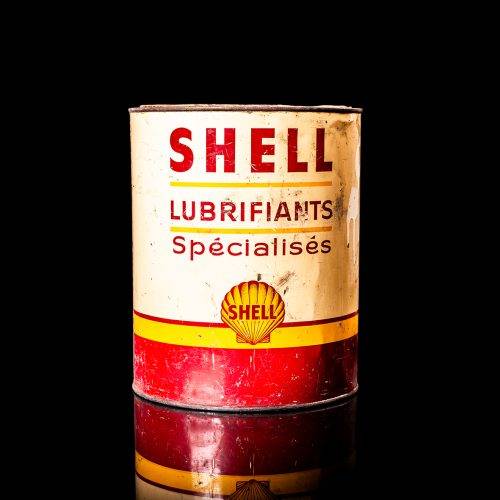 Rare and unique vintage Shell grease can from 1900–1950 with a red base and yellow detailing, featuring the classic Shell logo. This antique lubricant tin is displayed in a studio setting against a solid black background."