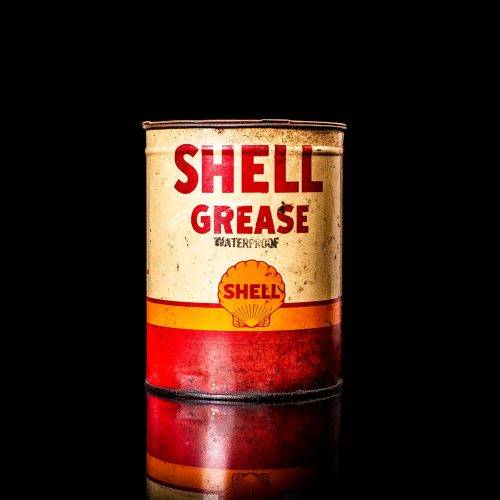 Vintage Shell oil cans with red and yellow branding from the 1900-1920 old logo Vintage Shell oil cans from 1900-19255, featuring the old logo. The photo showcases an antique tin red with yellow accents, displaying the historic Shell emblem. Shot in a studio against a solid black background