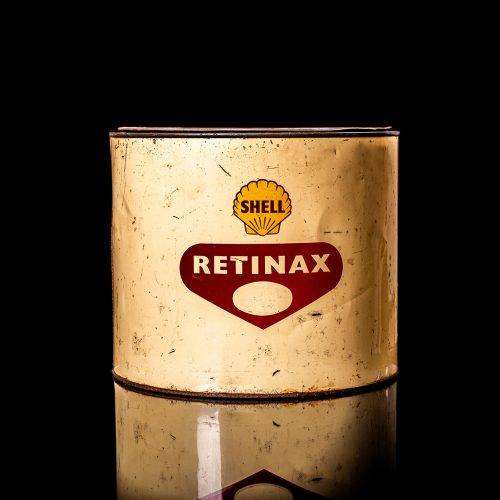Rare and unique vintage Shell grease can from 1900–1950 with a red base and yellow detailing, featuring the classic Shell logo. This antique lubricant tin is displayed in a studio setting against a solid black background."