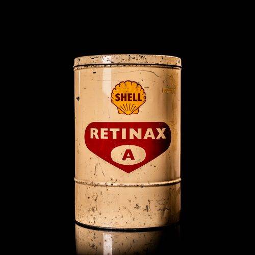 Vintage Shell oil cans with red and yellow branding from the 1900-1920 old logo Vintage Shell oil cans from 1900-19255, featuring the old logo. The photo showcases an antique tin red with yellow accents, displaying the historic Shell emblem. Shot in a studio against a solid black background