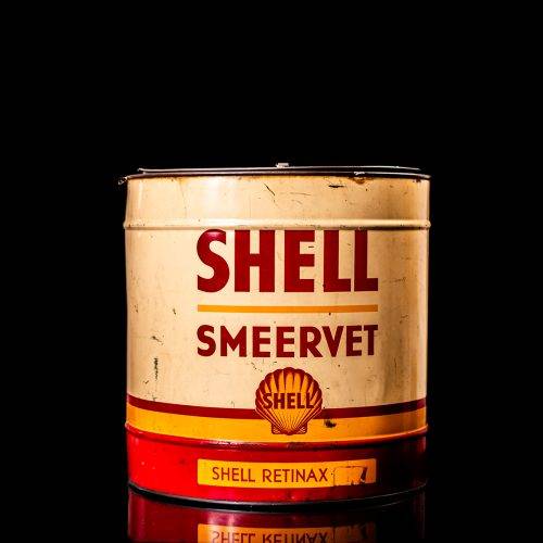 Vintage Shell oil cans with red and yellow branding from the 1900-1920 old logo Vintage Shell oil cans from 1900-19255, featuring the old logo. The photo showcases an antique tin red with yellow accents, displaying the historic Shell emblem. Shot in a studio against a solid black background
