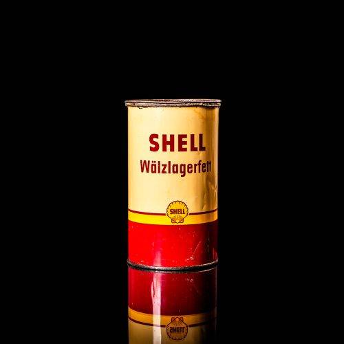 Vintage Shell oil cans with red and yellow branding from the 1900-1920 old logo Vintage Shell oil cans from 1900-19255, featuring the old logo. The photo showcases an antique tin red with yellow accents, displaying the historic Shell emblem. Shot in a studio against a solid black background