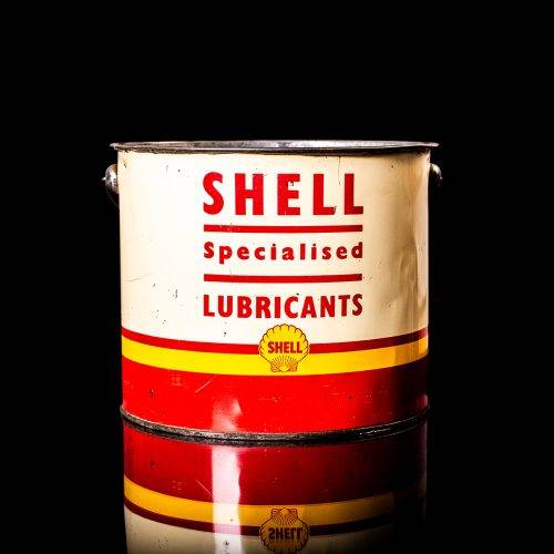 Vintage Shell oil cans with red and yellow branding from the 1900-1920 old logo Vintage Shell oil cans from 1900-19255, featuring the old logo. The photo showcases an antique tin red with yellow accents, displaying the historic Shell emblem. Shot in a studio against a solid black background