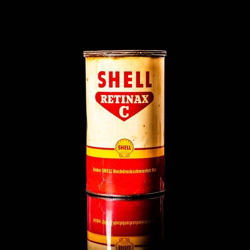 Vintage Shell oil cans with red and yellow branding from the 1900-1920 old logo Vintage Shell oil cans from 1900-19255, featuring the old logo. The photo showcases an antique tin red with yellow accents, displaying the historic Shell emblem. Shot in a studio against a solid black background