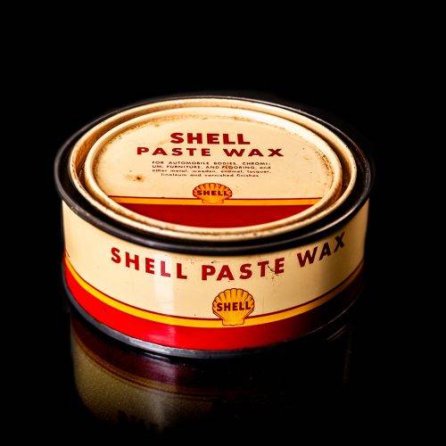 Rare and unique vintage Shell grease can from 1900–1950 with a red base and yellow detailing, featuring the classic Shell logo. This antique lubricant tin is displayed in a studio setting against a solid black background."
