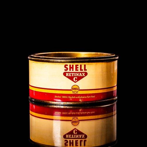 Vintage Shell oil cans with red and yellow branding from the 1900-1920 old logo Vintage Shell oil cans from 1900-19255, featuring the old logo. The photo showcases an antique tin red with yellow accents, displaying the historic Shell emblem. Shot in a studio against a solid black background
