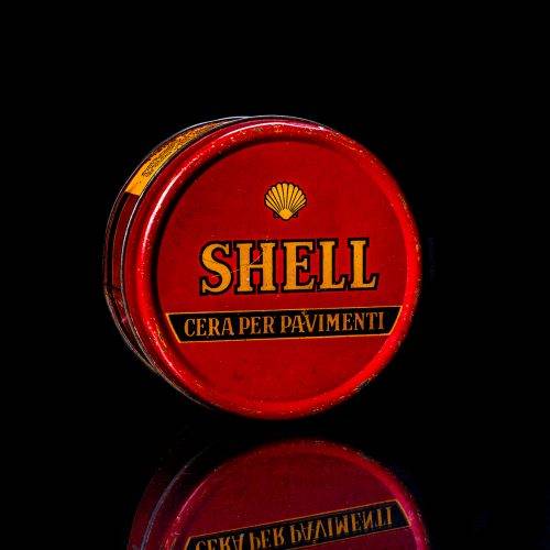 Vintage Shell oil cans with red and yellow branding from the 1900-1920 old logo Vintage Shell oil cans from 1900-19255, featuring the old logo. The photo showcases an antique tin red with yellow accents, displaying the historic Shell emblem. Shot in a studio against a solid black background