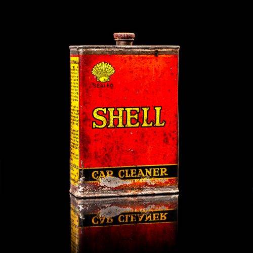 Vintage Shell oil cans with red and yellow branding from the 1900-1920 old logo Vintage Shell oil cans from 1900-19255, featuring the old logo. The photo showcases an antique tin red with yellow accents, displaying the historic Shell emblem. Shot in a studio against a solid black background