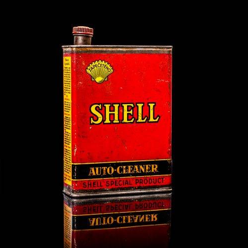 Rare and unique vintage mini Shell oil can from 1900–1950 with red and yellow accents, featuring the classic Shell logo. This small antique tin is displayed in a studio setting against a solid black background. lubricant,cleaner, outboard, motor oil, sealant, valve lubricant, two cycle, glass cleaner oil, shell cans