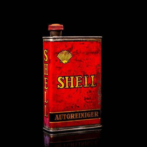 Rare and unique vintage mini Shell oil can from 1900–1950 with red and yellow accents, featuring the classic Shell logo. This small antique tin is displayed in a studio setting against a solid black background. lubricant,cleaner, outboard, motor oil, sealant, valve lubricant, two cycle, glass cleaner oil, shell cans