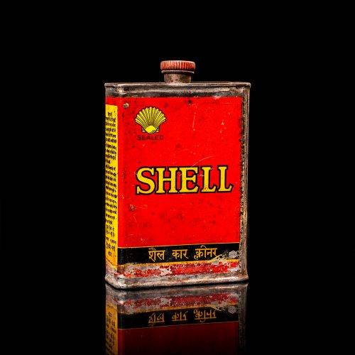 Rare and unique vintage mini Shell oil can from 1900–1950 with red and yellow accents, featuring the classic Shell logo. This small antique tin is displayed in a studio setting against a solid black background. lubricant,cleaner, outboard, motor oil, sealant, valve lubricant, two cycle, glass cleaner oil, shell cans