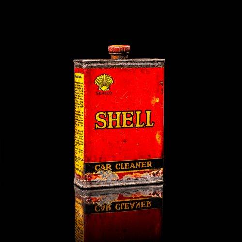 Vintage Shell oil cans with red and yellow branding from the 1900-1920 old logo Vintage Shell oil cans from 1900-19255, featuring the old logo. The photo showcases an antique tin red with yellow accents, displaying the historic Shell emblem. Shot in a studio against a solid black background