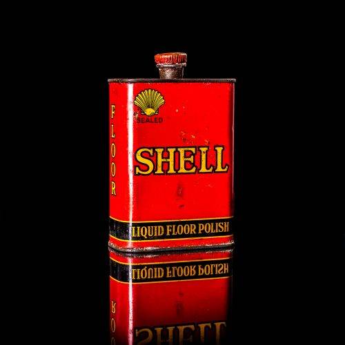 Rare and unique vintage mini Shell oil can from 1900–1950 with red and yellow accents, featuring the classic Shell logo. This small antique tin is displayed in a studio setting against a solid black background. lubricant,cleaner, outboard, motor oil, sealant, valve lubricant, two cycle, glass cleaner oil, shell cans