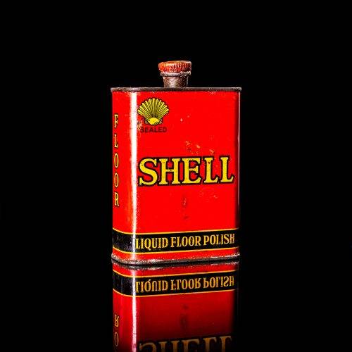 Vintage Shell oil cans with red and yellow branding from the 1900-1920 old logo Vintage Shell oil cans from 1900-19255, featuring the old logo. The photo showcases an antique tin red with yellow accents, displaying the historic Shell emblem. Shot in a studio against a solid black background