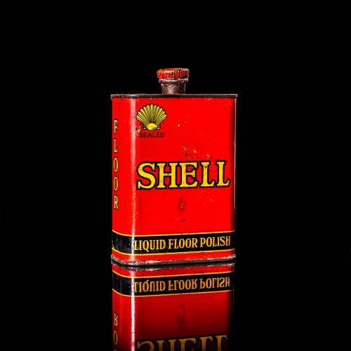 Rare and unique vintage mini Shell oil can from 1900–1950 with red and yellow accents, featuring the classic Shell logo. This small antique tin is displayed in a studio setting against a solid black background. lubricant,cleaner, outboard, motor oil, sealant, valve lubricant, two cycle, glass cleaner oil, shell cans