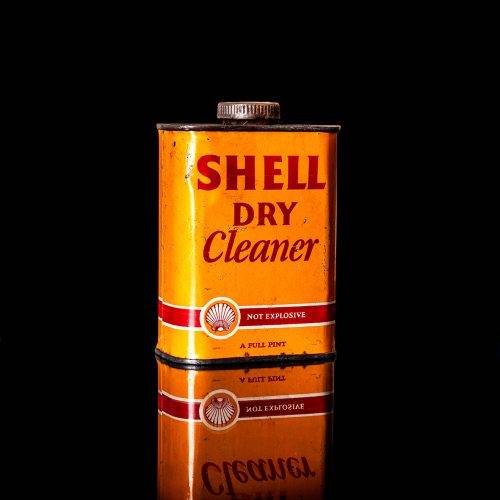 Vintage Shell oil cans with red and yellow branding from the 1900-1920 old logo Vintage Shell oil cans from 1900-19255, featuring the old logo. The photo showcases an antique tin red with yellow accents, displaying the historic Shell emblem. Shot in a studio against a solid black background
