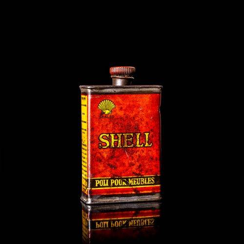 Rare and unique vintage mini Shell oil can from 1900–1950 with red and yellow accents, featuring the classic Shell logo. This small antique tin is displayed in a studio setting against a solid black background. lubricant,cleaner, outboard, motor oil, sealant, valve lubricant, two cycle, glass cleaner oil, shell cans