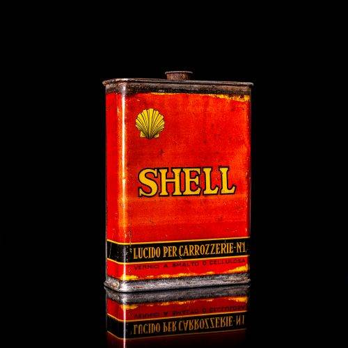 Rare and unique vintage mini Shell oil can from 1900–1950 with red and yellow accents, featuring the classic Shell logo. This small antique tin is displayed in a studio setting against a solid black background. lubricant,cleaner, outboard, motor oil, sealant, valve lubricant, two cycle, glass cleaner oil, shell cans