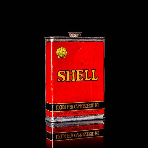Vintage Shell oil cans with red and yellow branding from the 1900-1920 old logo Vintage Shell oil cans from 1900-19255, featuring the old logo. The photo showcases an antique tin red with yellow accents, displaying the historic Shell emblem. Shot in a studio against a solid black background
