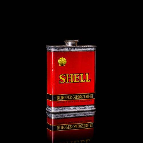 Vintage Shell oil cans with red and yellow branding from the 1900-1920 old logo Vintage Shell oil cans from 1900-19255, featuring the old logo. The photo showcases an antique tin red with yellow accents, displaying the historic Shell emblem. Shot in a studio against a solid black background