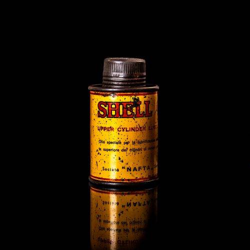 Rare and unique vintage mini Shell oil can from 1900–1950 with red and yellow accents, featuring the classic Shell logo. This small antique tin is displayed in a studio setting against a solid black background." lubricant,cleaner, outboard, motor oil, sealant, valve lubricant, two cycle, glass cleaner oil, shell cans