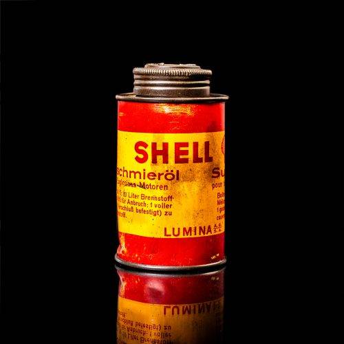 Rare and unique vintage mini Shell oil can from 1900–1950 with red and yellow accents, featuring the classic Shell logo. This small antique tin is displayed in a studio setting against a solid black background." lubricant,cleaner, outboard, motor oil, sealant, valve lubricant, two cycle, glass cleaner oil, shell cans
