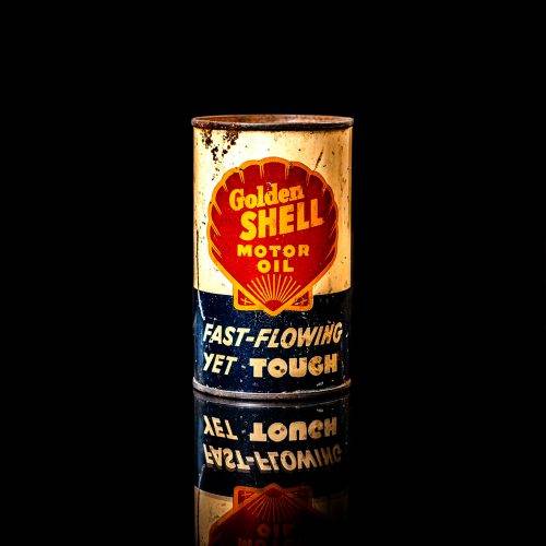 Rare and unique vintage mini Shell oil can from 1900–1950 with red and yellow accents, featuring the classic Shell logo. This small antique tin is displayed in a studio setting against a solid black background." lubricant,cleaner, outboard, motor oil, sealant, valve lubricant, two cycle, glass cleaner oil, shell cans