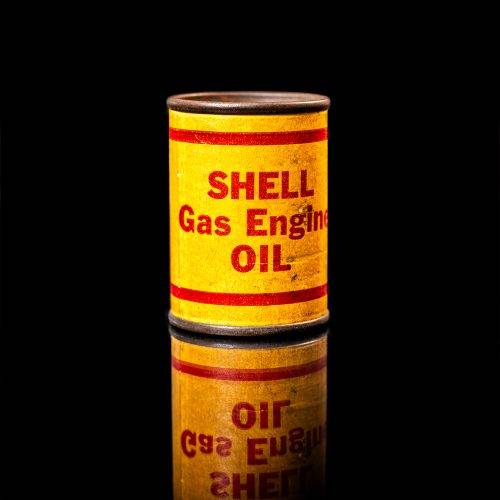 Vintage Shell oil cans with red and yellow branding from the 1900-1920 old logo Vintage Shell oil cans from 1900-19255, featuring the old logo. The photo showcases an antique tin red with yellow accents, displaying the historic Shell emblem. Shot in a studio against a solid black background