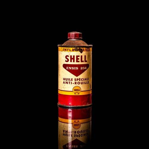 Vintage Shell oil cans with red and yellow branding from the 1900-1920 old logo Vintage Shell oil cans from 1900-19255, featuring the old logo. The photo showcases an antique tin red with yellow accents, displaying the historic Shell emblem. Shot in a studio against a solid black background