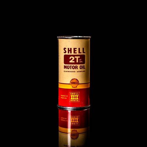 Vintage Shell oil cans with red and yellow branding from the 1900-1920 old logo Vintage Shell oil cans from 1900-19255, featuring the old logo. The photo showcases an antique tin red with yellow accents, displaying the historic Shell emblem. Shot in a studio against a solid black background