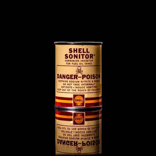 Vintage Shell oil cans with red and yellow branding from the 1900-1920 old logo Vintage Shell oil cans from 1900-19255, featuring the old logo. The photo showcases an antique tin red with yellow accents, displaying the historic Shell emblem. Shot in a studio against a solid black background