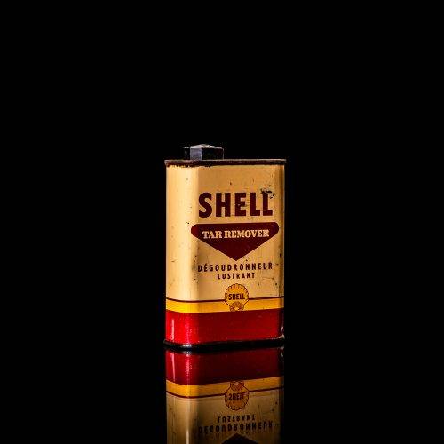 Vintage Shell oil cans with red and yellow branding from the 1900-1920 old logo Vintage Shell oil cans from 1900-19255, featuring the old logo. The photo showcases an antique tin red with yellow accents, displaying the historic Shell emblem. Shot in a studio against a solid black background