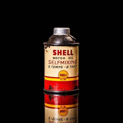 Vintage Shell oil cans with red and yellow branding from the 1900-1920 old logo Vintage Shell oil cans from 1900-19255, featuring the old logo. The photo showcases an antique tin red with yellow accents, displaying the historic Shell emblem. Shot in a studio against a solid black background