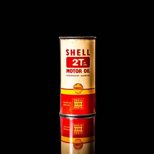 Vintage Shell oil cans with red and yellow branding from the 1900-1920 old logo Vintage Shell oil cans from 1900-19255, featuring the old logo. The photo showcases an antique tin red with yellow accents, displaying the historic Shell emblem. Shot in a studio against a solid black background