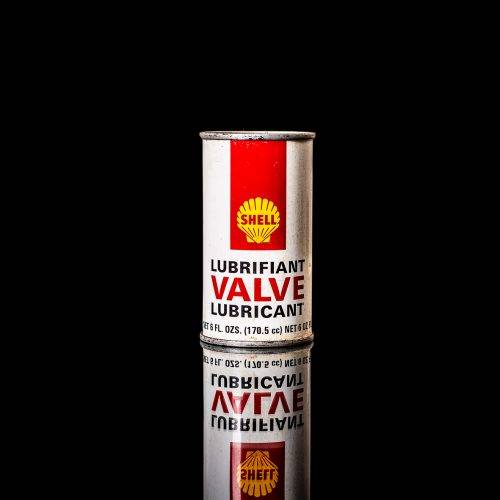 Rare and unique vintage mini Shell oil can from 1900–1950 with red and yellow accents, featuring the classic Shell logo. This small antique tin is displayed in a studio setting against a solid black background." lubricant,cleaner, outboard, motor oil, sealant, valve lubricant, two cycle, glass cleaner oil, shell cans