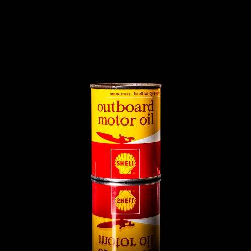 Vintage Shell oil cans with red and yellow branding from the 1900-1920 old logo Vintage Shell oil cans from 1900-19255, featuring the old logo. The photo showcases an antique tin red with yellow accents, displaying the historic Shell emblem. Shot in a studio against a solid black background