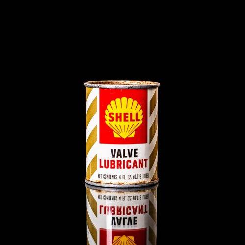 Rare and unique vintage mini Shell oil can from 1900–1950 with red and yellow accents, featuring the classic Shell logo. This small antique tin is displayed in a studio setting against a solid black background." lubricant,cleaner, outboard, motor oil, sealant, valve lubricant, two cycle, glass cleaner oil, shell cans