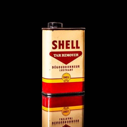 Vintage Shell oil cans with red and yellow branding from the 1900-1920 old logo Vintage Shell oil cans from 1900-19255, featuring the old logo. The photo showcases an antique tin red with yellow accents, displaying the historic Shell emblem. Shot in a studio against a solid black background