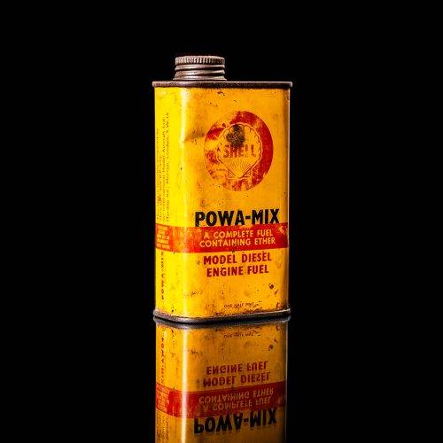 Rare and unique vintage mini Shell oil can from 1900–1950 with red and yellow accents, featuring the classic Shell logo. This small antique tin is displayed in a studio setting against a solid black background." lubricant,cleaner, outboard, motor oil, sealant, valve lubricant, two cycle, glass cleaner oil, shell cans