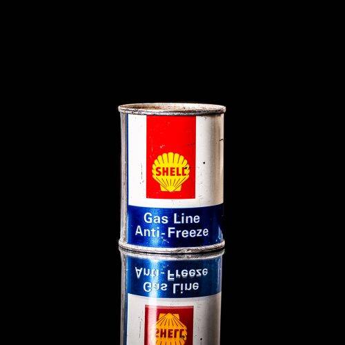 Rare and unique vintage mini Shell oil can from 1900–1950 with red and yellow accents, featuring the classic Shell logo. This small antique tin is displayed in a studio setting against a solid black background." lubricant,cleaner, outboard, motor oil, sealant, valve lubricant, two cycle, glass cleaner oil, shell cans