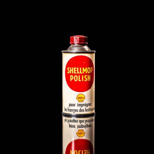 Vintage Shell oil cans with red and yellow branding from the 1900-1920 old logo Vintage Shell oil cans from 1900-19255, featuring the old logo. The photo showcases an antique tin red with yellow accents, displaying the historic Shell emblem. Shot in a studio against a solid black background