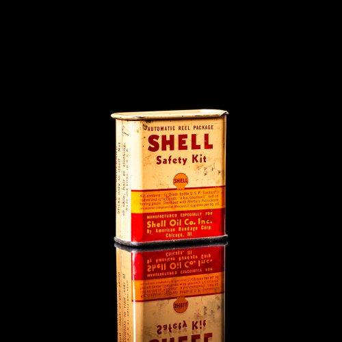 Vintage Shell oil cans with red and yellow branding from the 1900-1920 old logo Vintage Shell oil cans from 1900-19255, featuring the old logo. The photo showcases an antique tin red with yellow accents, displaying the historic Shell emblem. Shot in a studio against a solid black background