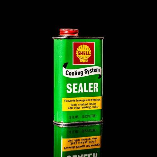 Rare and unique vintage mini Shell oil can from 1900–1950 with red and yellow accents, featuring the classic Shell logo. This small antique tin is displayed in a studio setting against a solid black background." lubricant,cleaner, outboard, motor oil, sealant, valve lubricant, two cycle, glass cleaner oil, shell cans