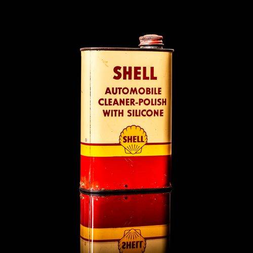 Vintage Shell oil cans with red and yellow branding from the 1900-1920 old logo Vintage Shell oil cans from 1900-19255, featuring the old logo. The photo showcases an antique tin red with yellow accents, displaying the historic Shell emblem. Shot in a studio against a solid black background