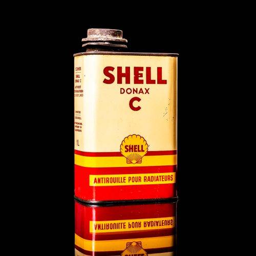 Vintage Shell oil cans with red and yellow branding from the 1900-1920 old logo Vintage Shell oil cans from 1900-19255, featuring the old logo. The photo showcases an antique tin red with yellow accents, displaying the historic Shell emblem. Shot in a studio against a solid black background