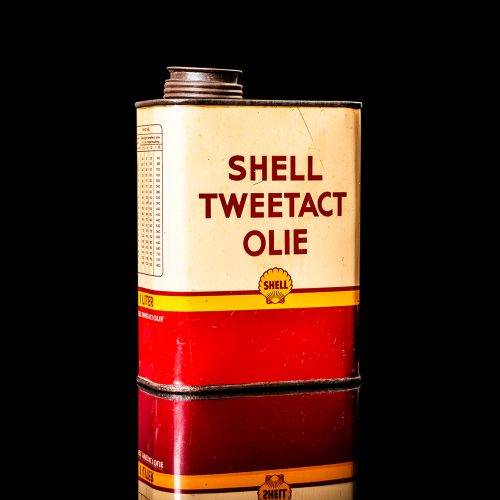 Vintage Shell oil cans with red and yellow branding from the 1900-1920 old logo Vintage Shell oil cans from 1900-19255, featuring the old logo. The photo showcases an antique tin red with yellow accents, displaying the historic Shell emblem. Shot in a studio against a solid black background